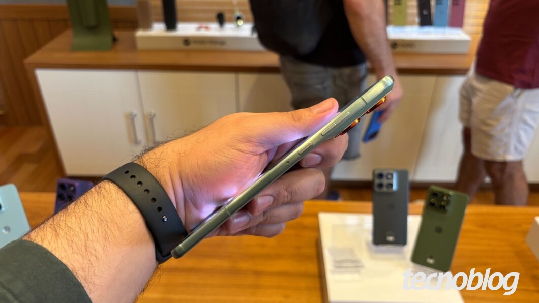 Motorola Edge 70 sendo visto lateralmente e segurado por uma mão com um relógio no pulso