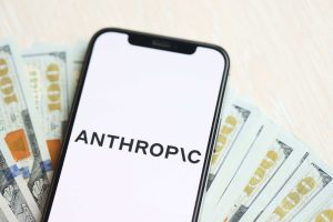 Celular com logo da Anthropic posicionado acima de notas de dólar.
