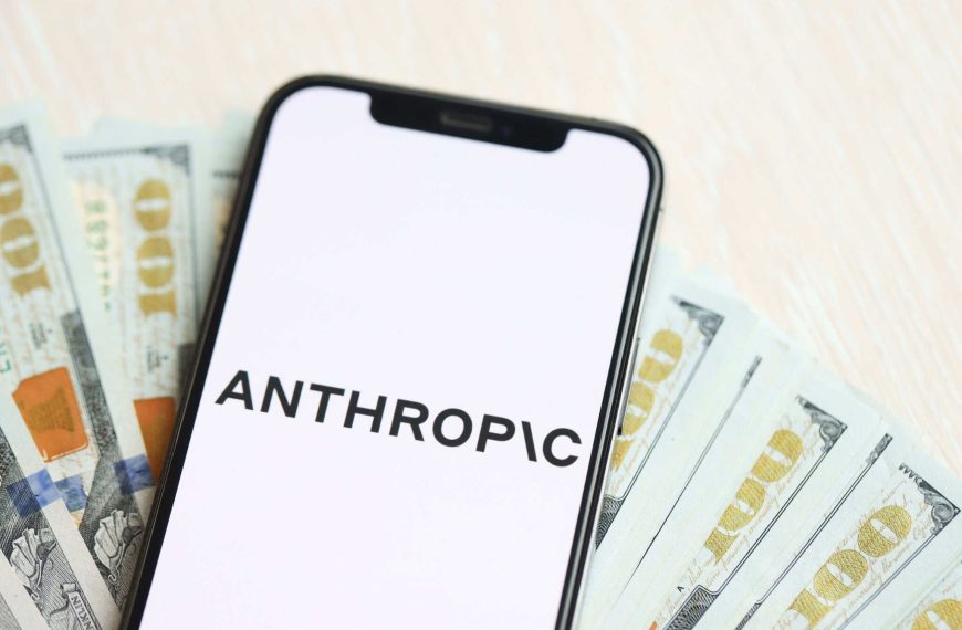 Celular com logo da Anthropic posicionado acima de notas de dólar.