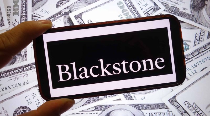 Logo da Blackstone em um smartphone; atrás, várias notas de dólar