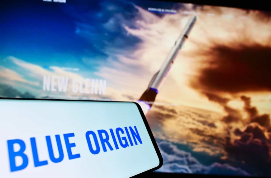 Logo da Blue Origin em um smartphone ao lado de uma imagem de um foguete
