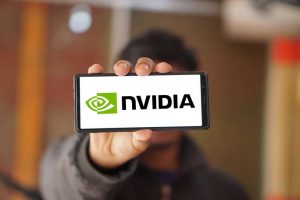 Pessoa segurando, na altura da cabeça, um smartphone na horizontal, no qual é visto o logo da Nvidia