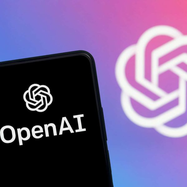 Logo da OpenAI em um smartphone e ao fundo
