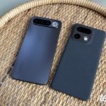 Dois smartphones cinza escuro virados para baixo, em uma bandeja de vime