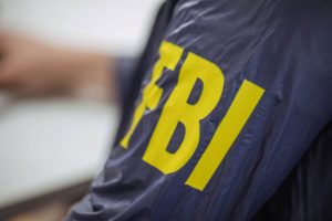 Detalhe de uniforme com a sigla FBI estampada em amarelo