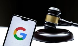 Ícone do Google em um smartphone ao lado de um martelo de juiz