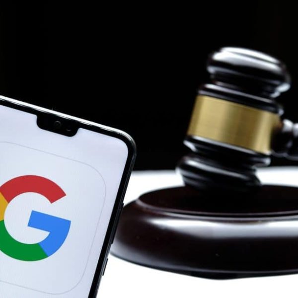 Ícone do Google em um smartphone ao lado de um martelo de juiz