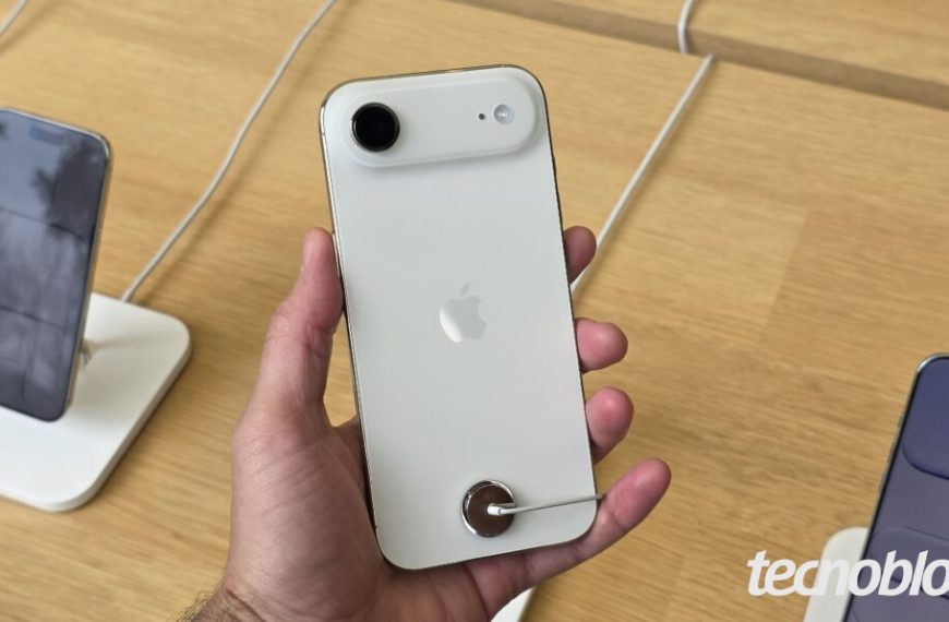 Imagem mostra um iPhone Air branco sendo segurado em uma mão. O modelo está virado com a parte traseira para a câmera.